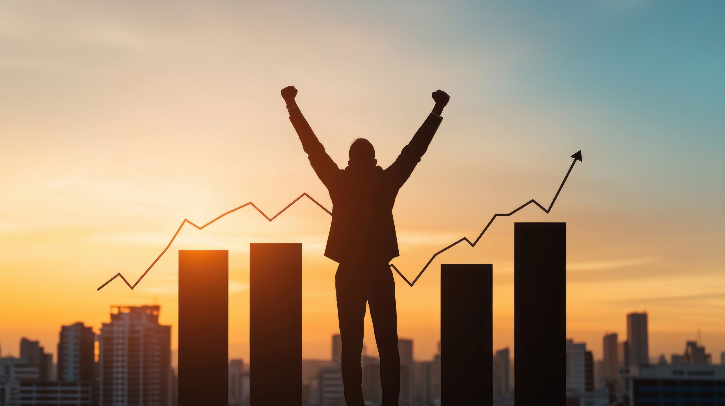 Silhouette of businessman celebrating success at sunset.