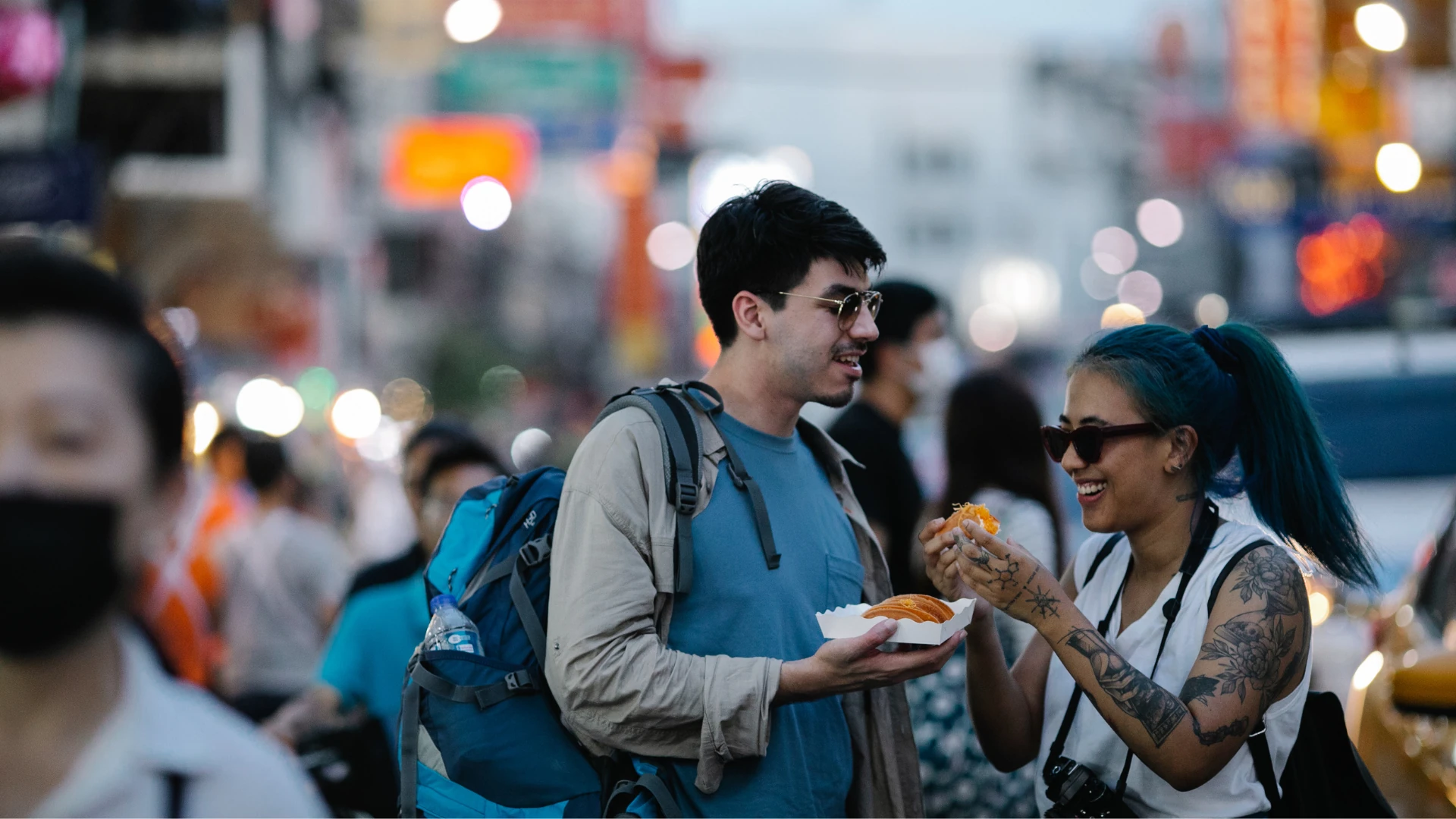 Couple eating food on a buy street