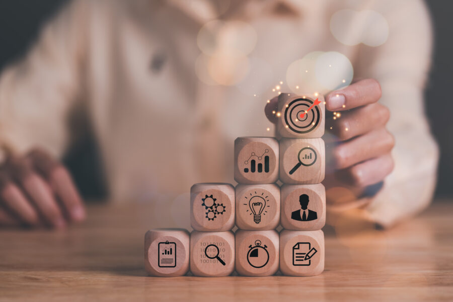 Man holding wooden block on table, businessman and arrow icons h